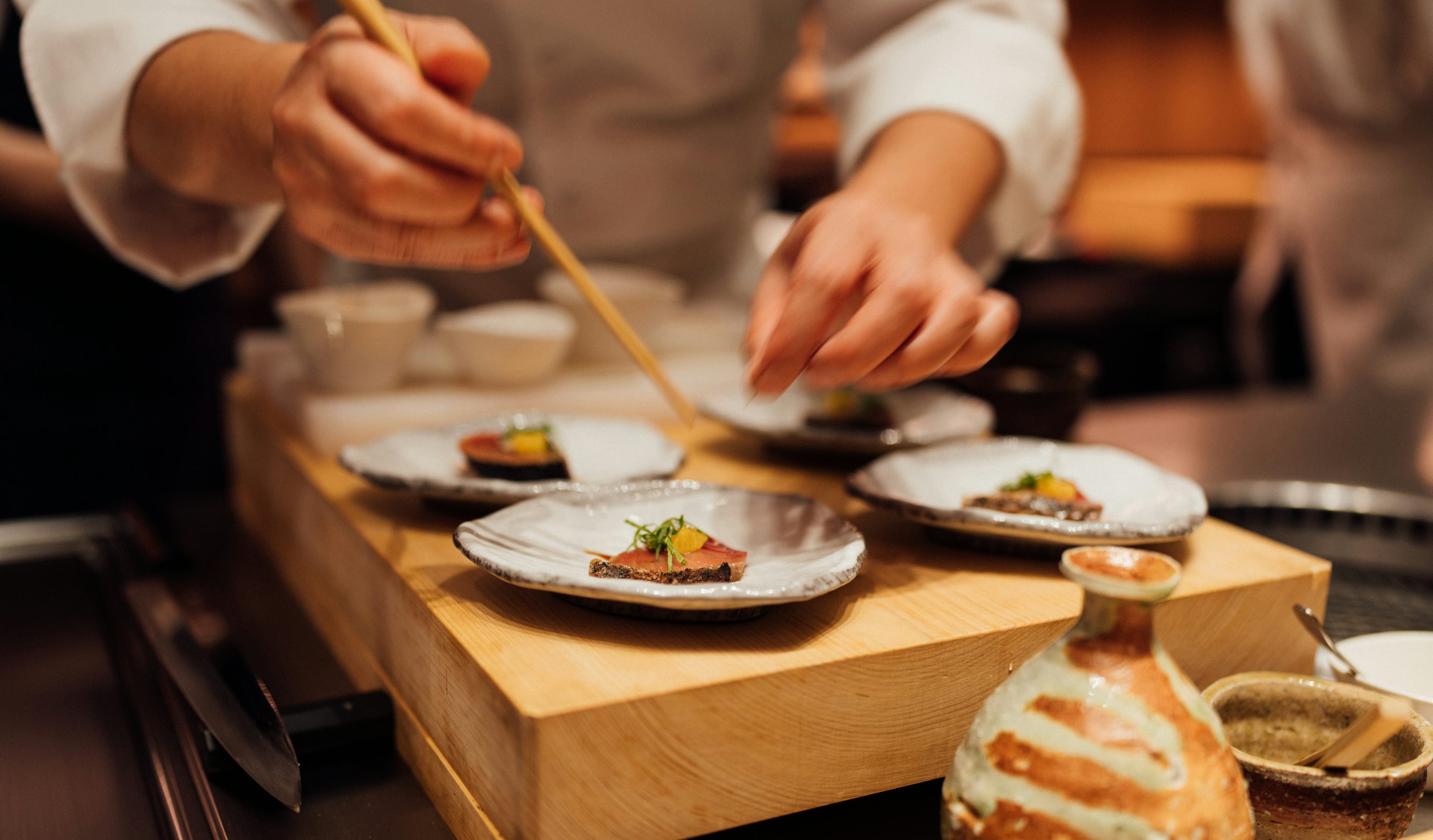 料理人が飲食店で料理を仕上げる様子